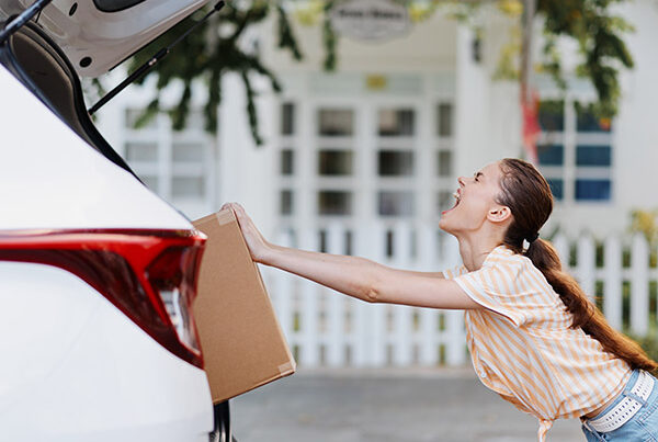Student trying to pack boxes into a small car.